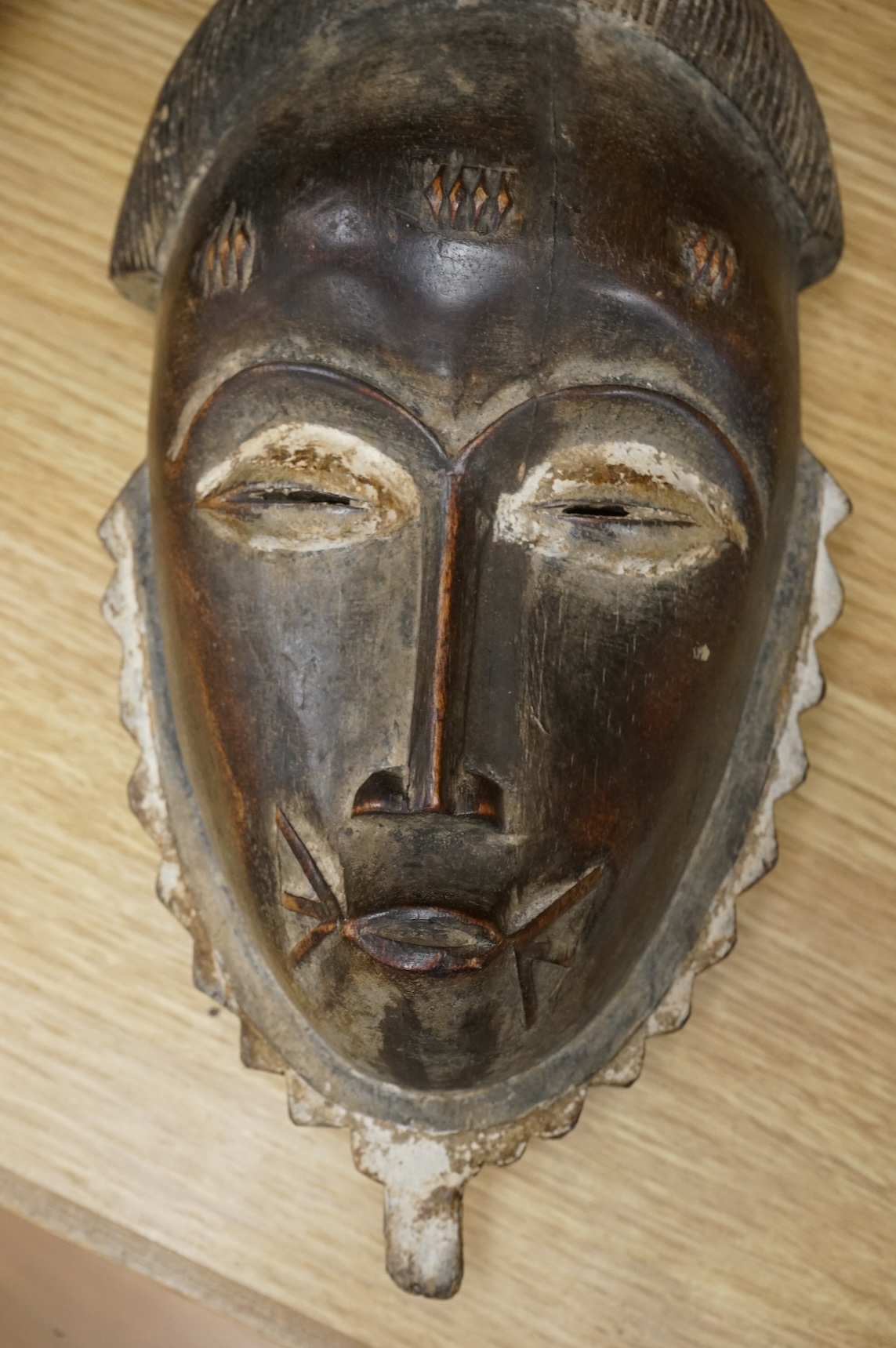 A carved Baule African mask from the Ivory Coast. 38cm high.